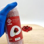 نمک حمام 950 گرمی هامانا رز در دست و برگ گل های رز قرمز روی زمین