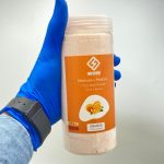 کوکتل پدیکور پودری پرتقال هامانا وزن 800 گرم گرفته شده در دست و نمای رو به رویی